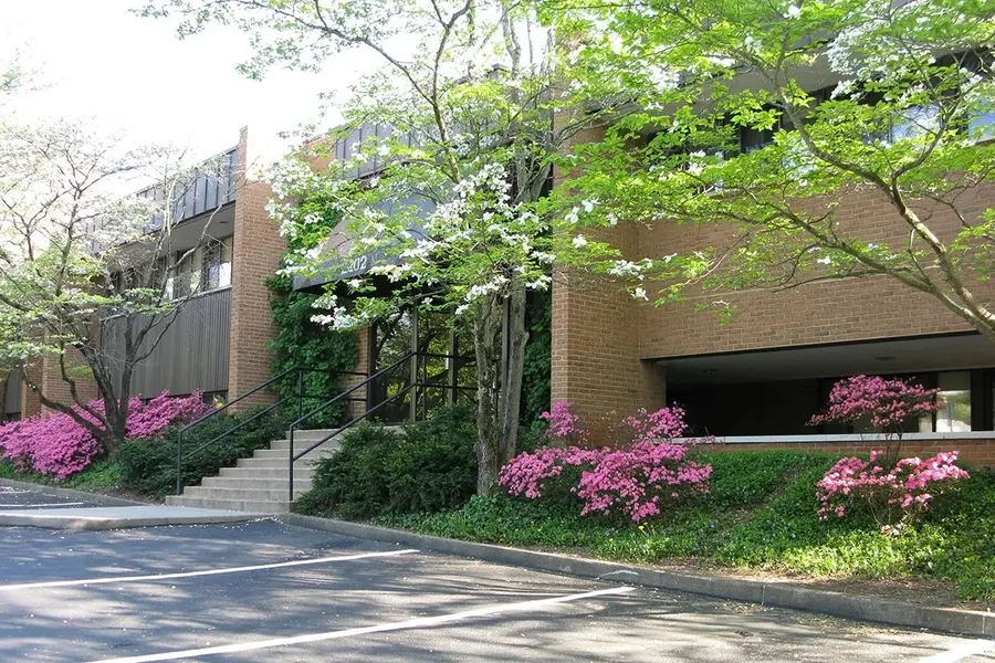 The brick office building at 2202 North Berkshire Road, with azaleas in bloom and parking out front.