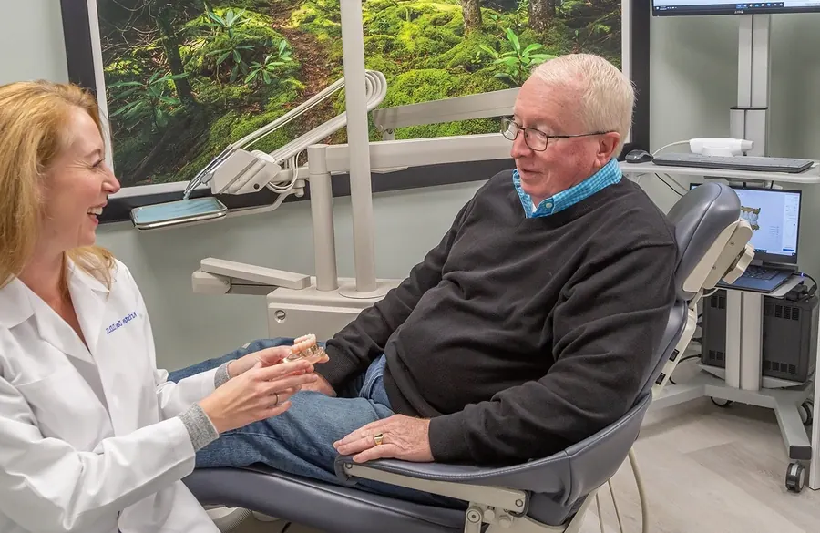 Dr. Krista Davis talking with a patient in the treatment chair.