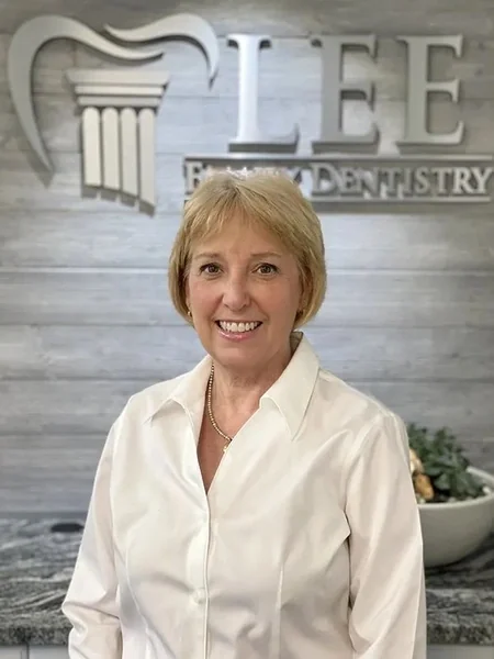 Brenda, of the Lee Family Dentistry team, in front of the office sign.